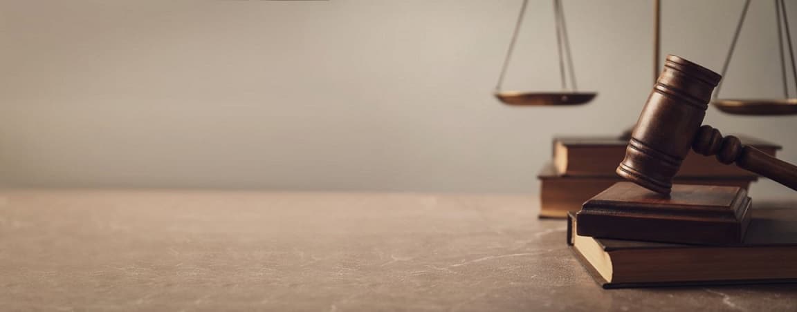 ترازوی عدالت بر روی کتاب های قدیمی حقوقی در اتاق وکیل صادقیه
