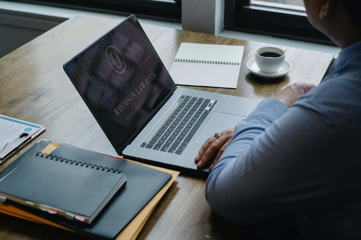 تصویر بهترین وکیل ونک کنار لبتاب و میز اداری